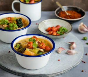 3 bowls of soup and a mug on a table